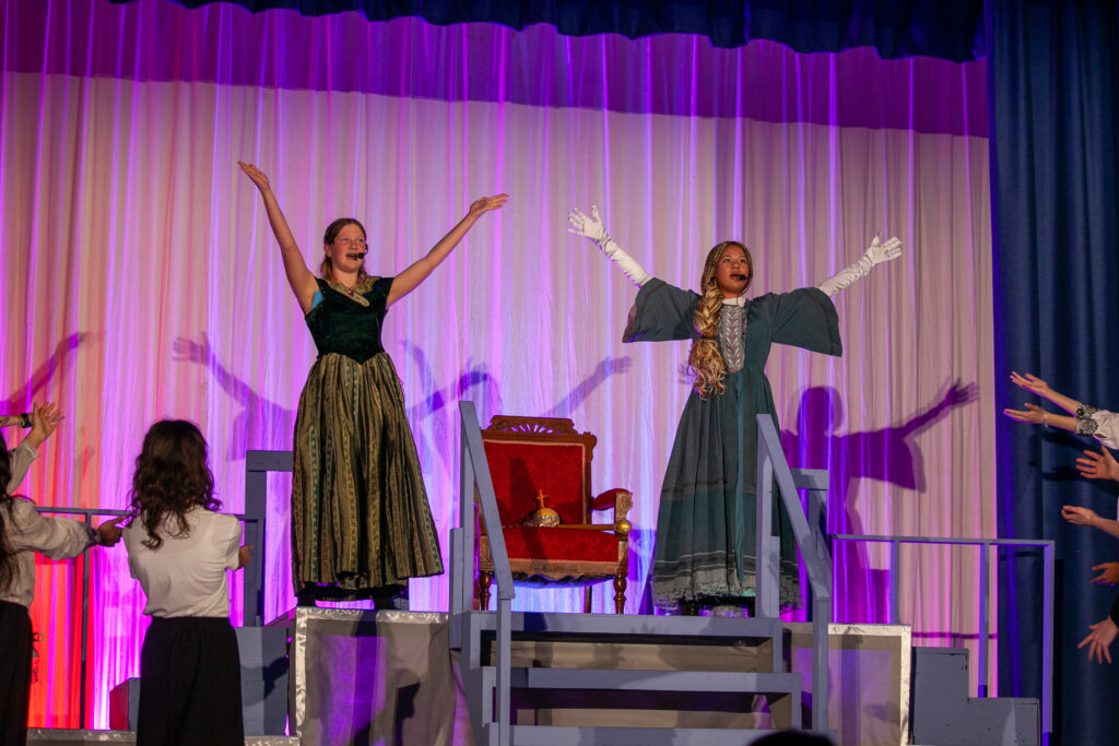Students performing on stage as Anna and Elsa from Disney's Frozen Jr.