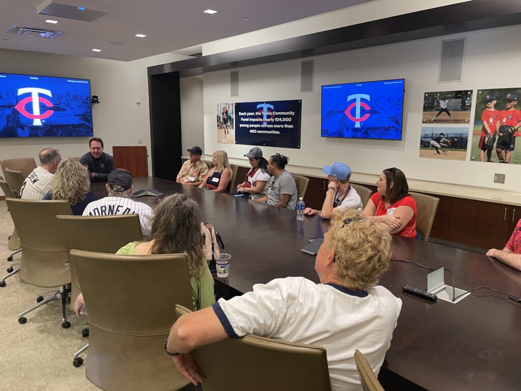 Sponsors in a conference room hearing from Twins executive.