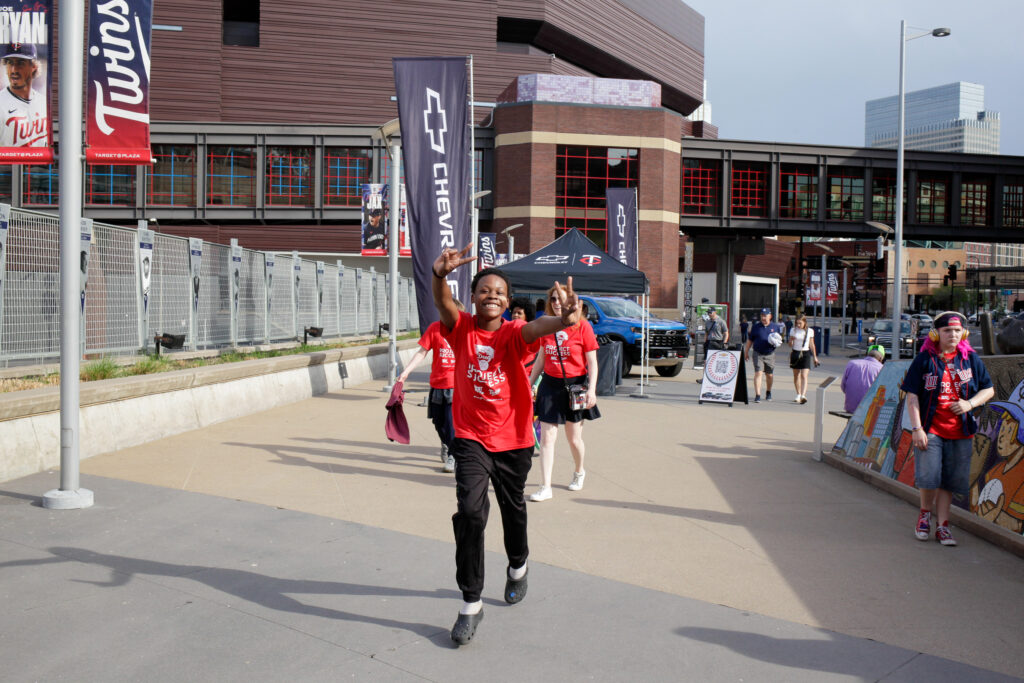 Student smiling and waiving as they enter the stadium.