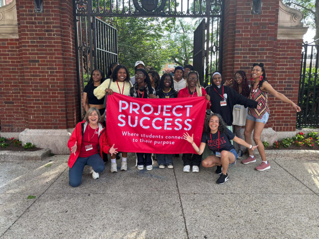 Students holding a Project Success flag outside of Howard University.