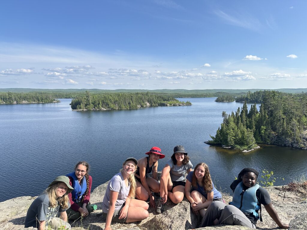Group of students smiling on a bluff.