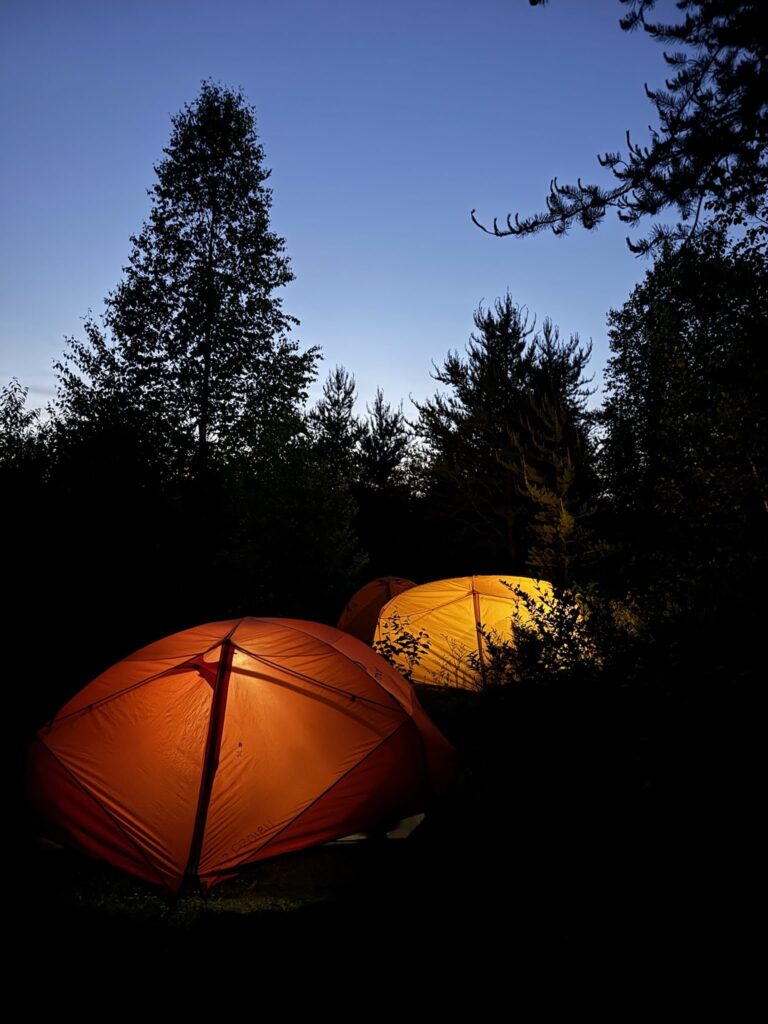 Two tents aglow in the wilderness.