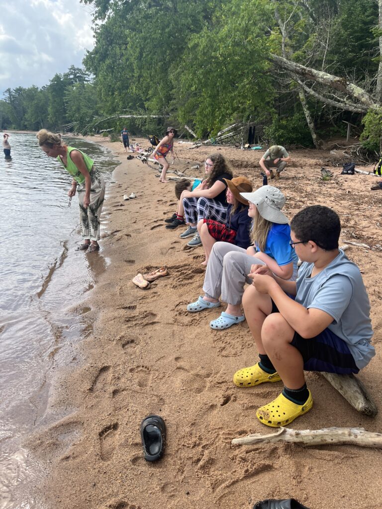 Students sitting on a beach.