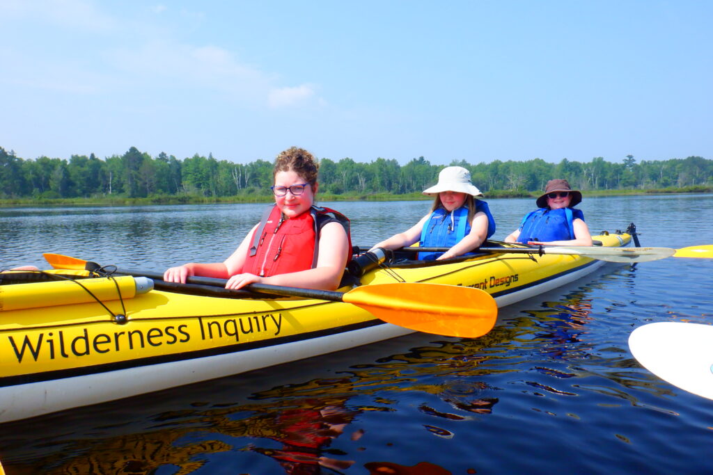 Students smiling in kayaks.