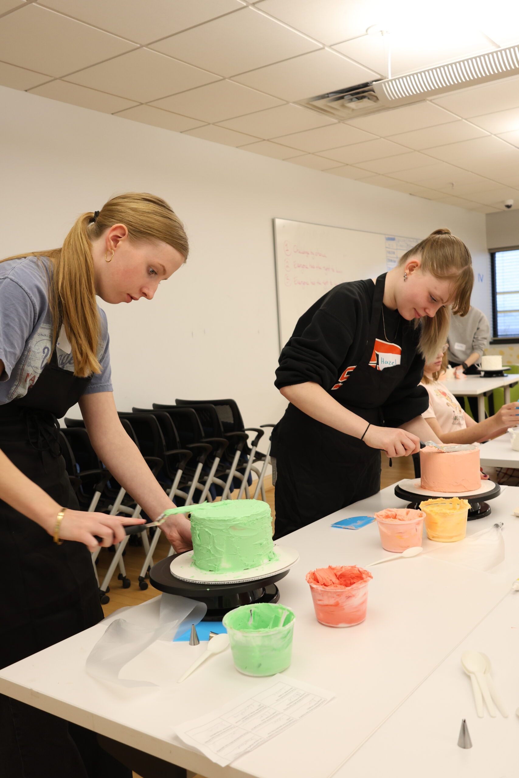 Students frosting cake.