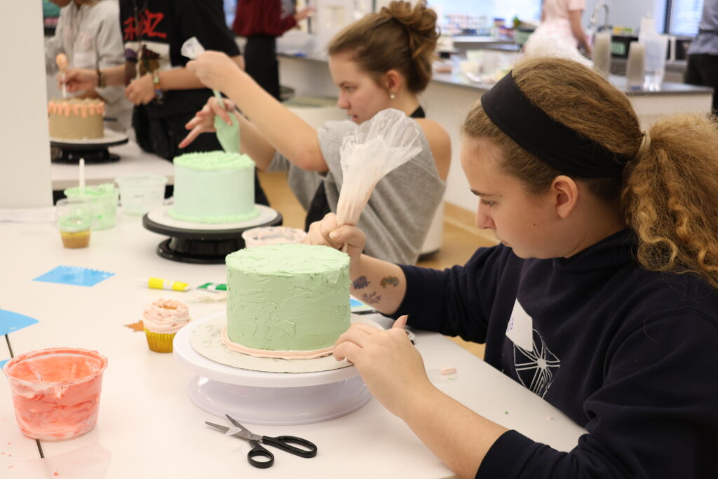 Students decorating cake.