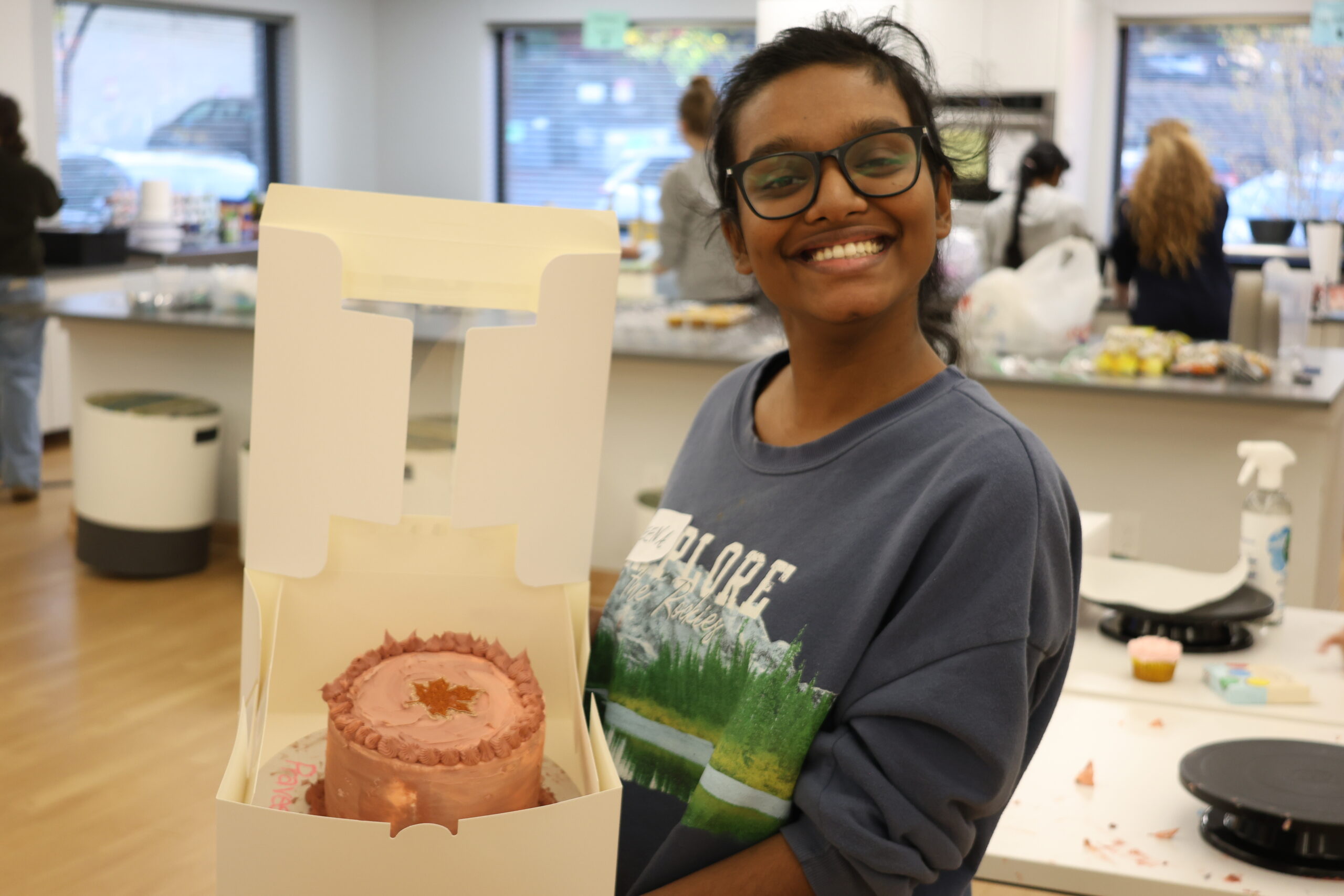 Student showing off her decorated cake.