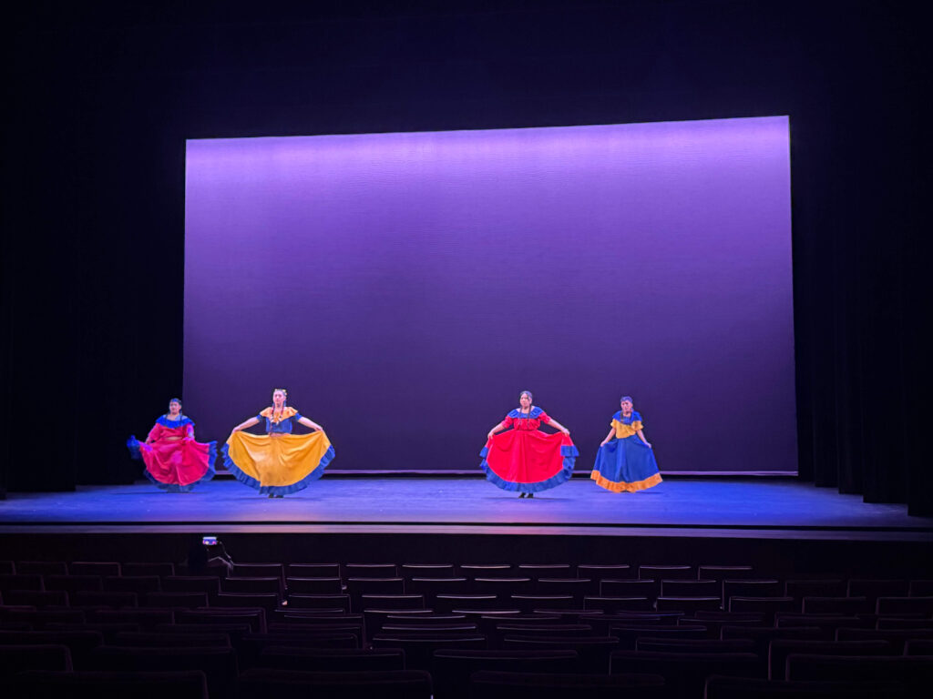 Four performers with flowing skirts.