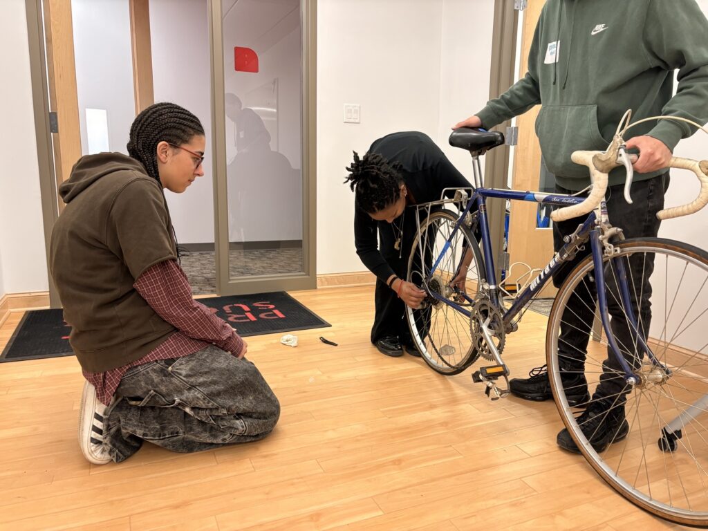 Liz and students working on a bike.