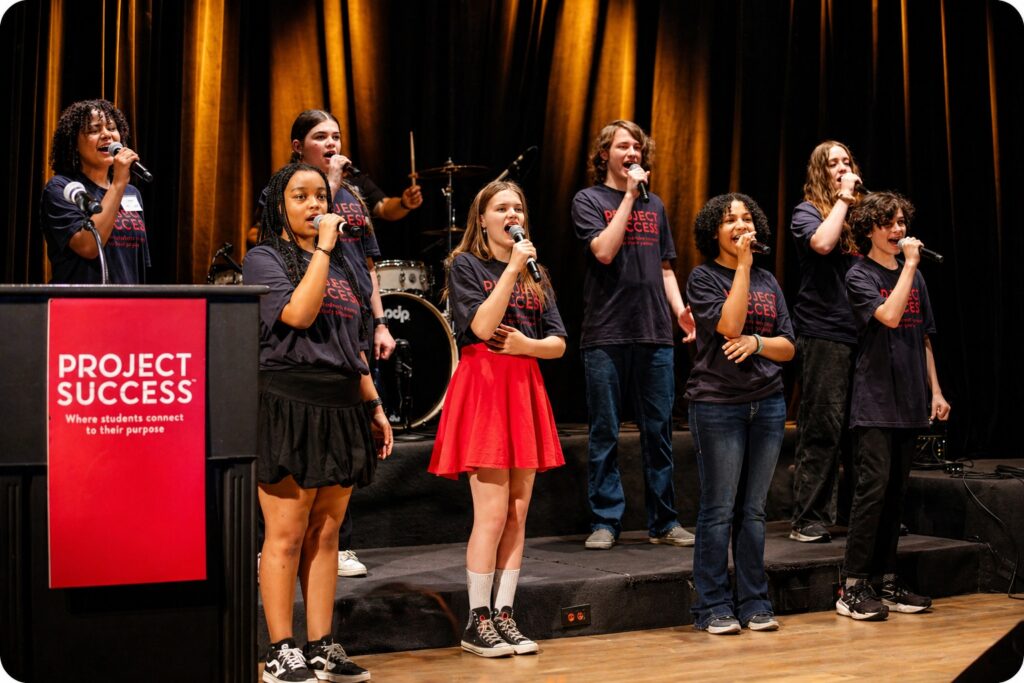 Students singing on stage.