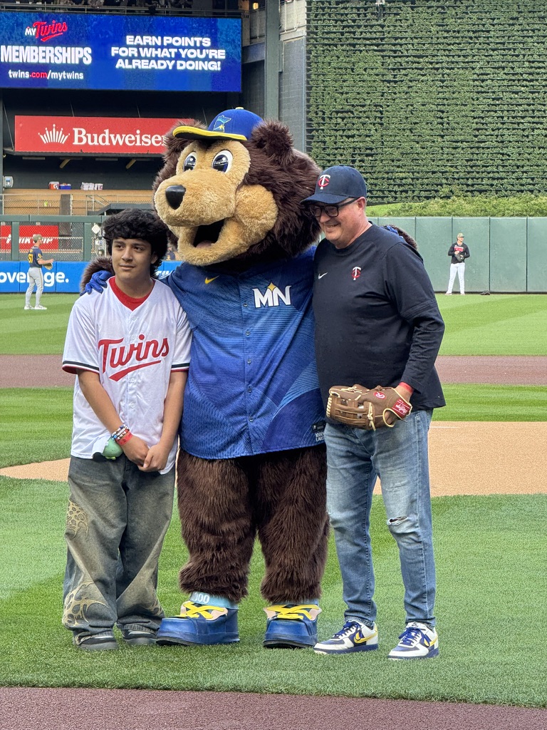 Student and board member smiling with TC Bear.